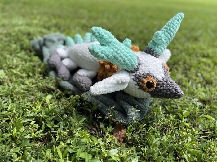 A white and grey dragon with yellow mane and eyes, and turquoise horns